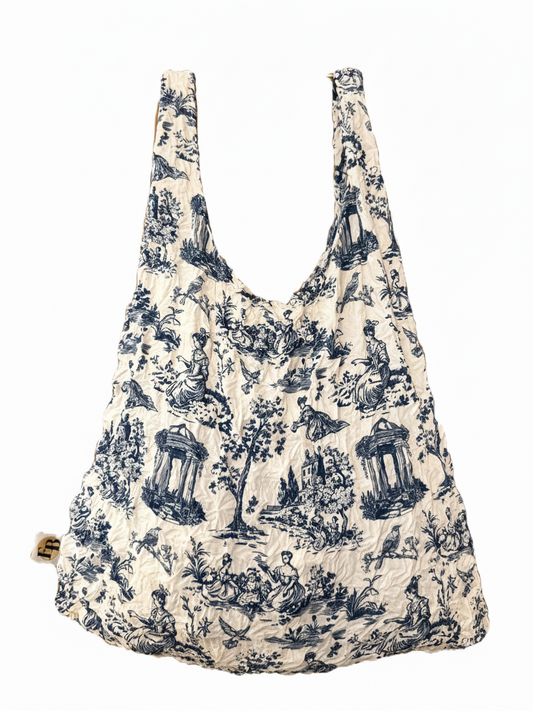 Be Bougie sustainable eco tote bag in a white and blue toile de jouy print with a stretchy, machine-washable fabric.