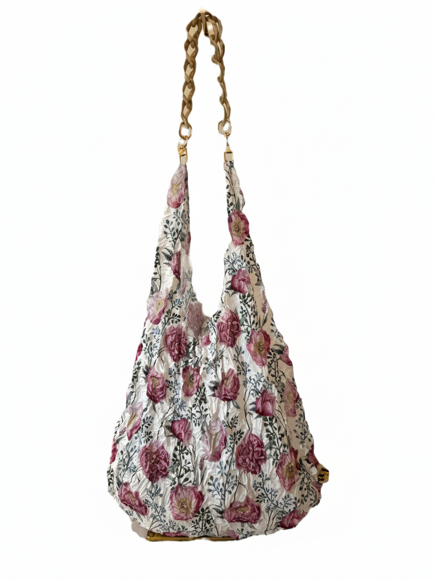 Be Bougie beige marbled acrylic chain handle attached to a floral print eco tote bag with gold-tone hardware