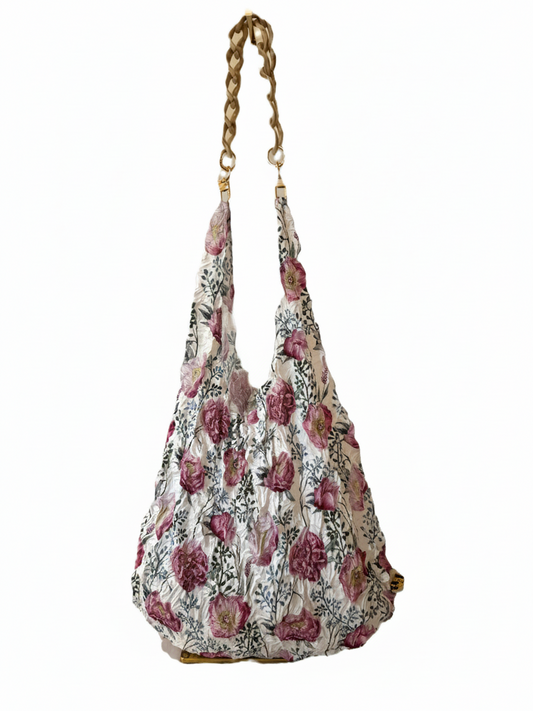 Be Bougie beige marbled acrylic chain handle attached to a floral print eco tote bag with gold-tone hardware