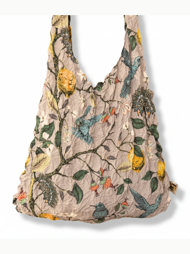 Be Bougie reusable shopping tote with a crinkled texture featuring a hummingbird, lemon, and botanical print.