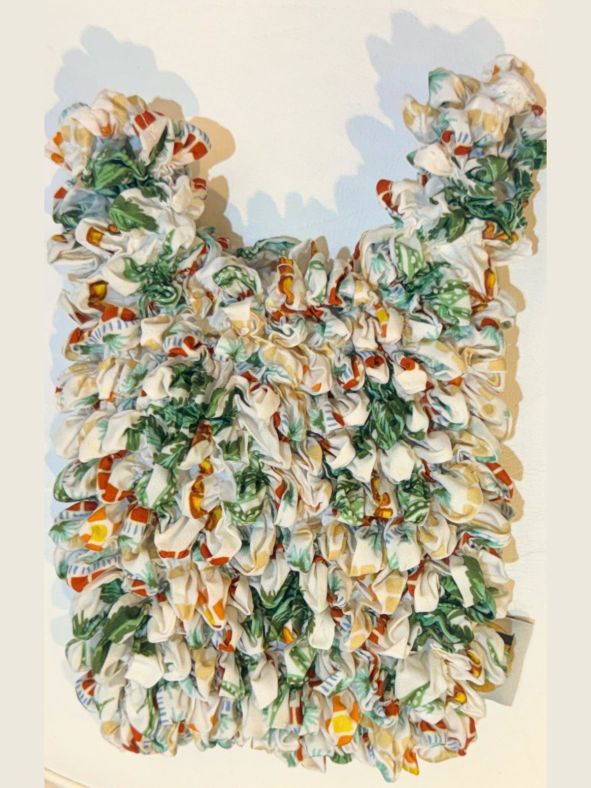 Be Bougie palm tree eco bag featuring a stretchy, crinkled fabric with a tropical mosaic print in green and cream.