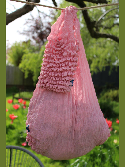 Be Bougie crepe pink sustainable stretchy eco shopper tote bag hanging outdoors in a garden setting