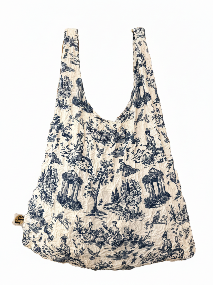 Be Bougie sustainable eco tote bag in a white and blue toile de jouy print with a stretchy, machine-washable fabric.