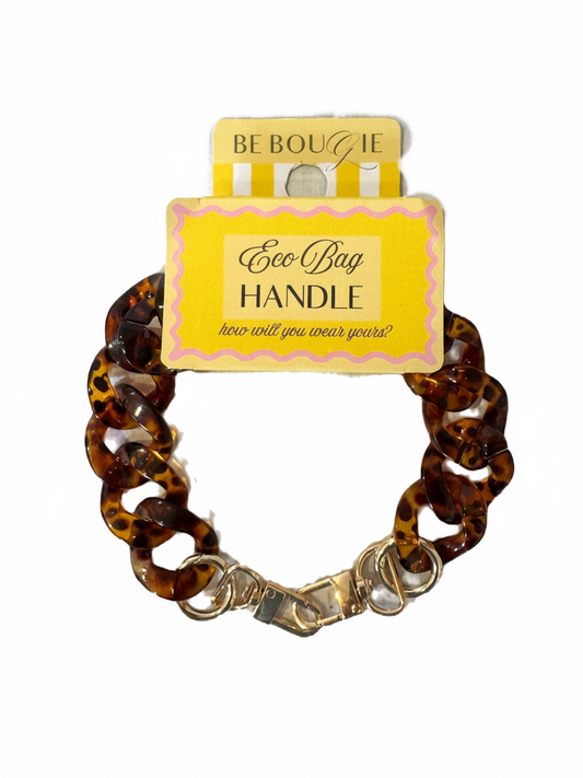 Be Bougie tortoiseshell chain link bag handle accessory with gold-tone metal clips on branded yellow display card.